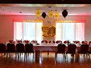 Apaļās jubilejas svinības ar svētku galdu, viesiem un dekorācijām